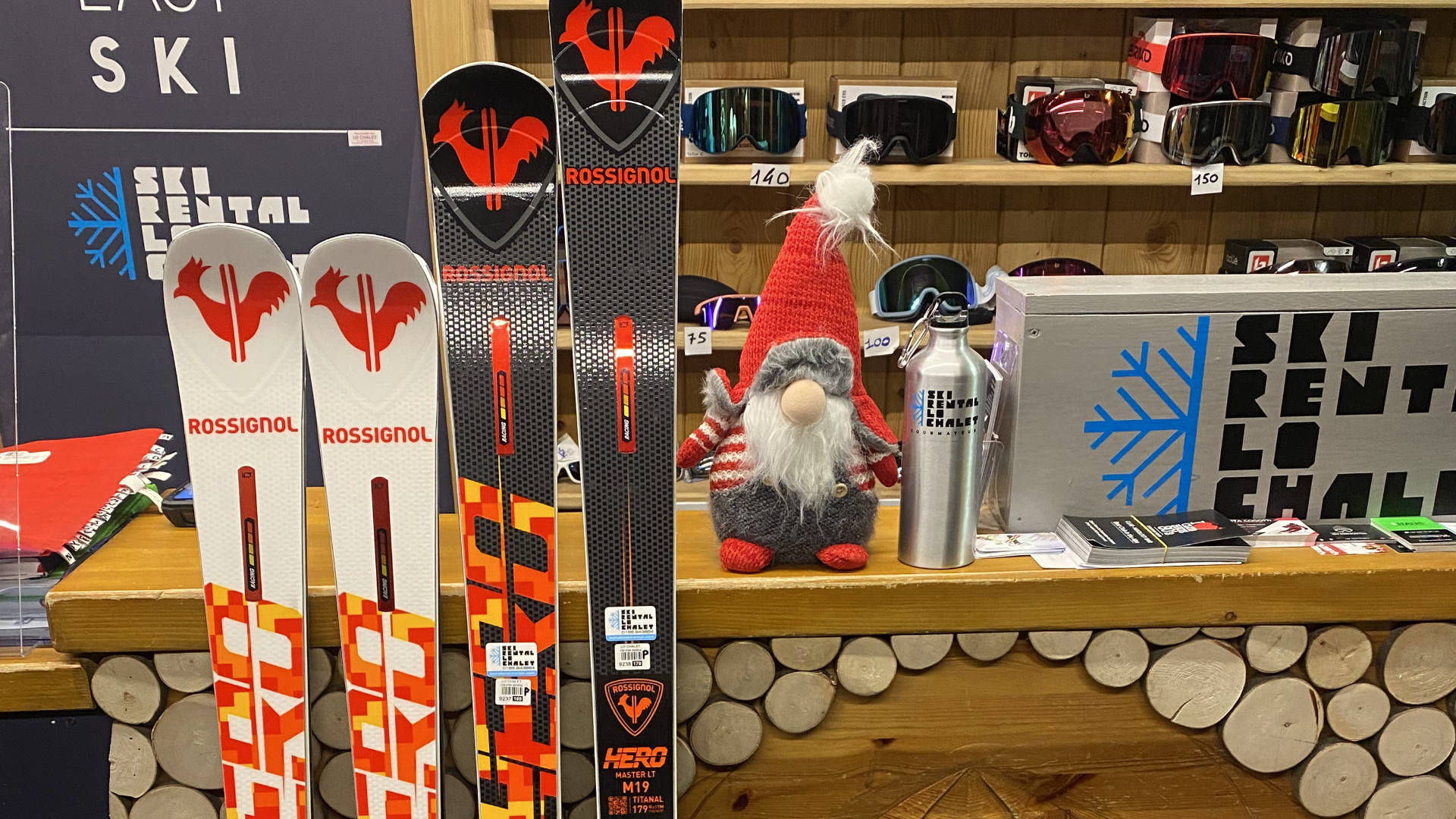 Rossignol skis on display at Lo Chalet rental shop, with the shop logo and a Christmas gnome